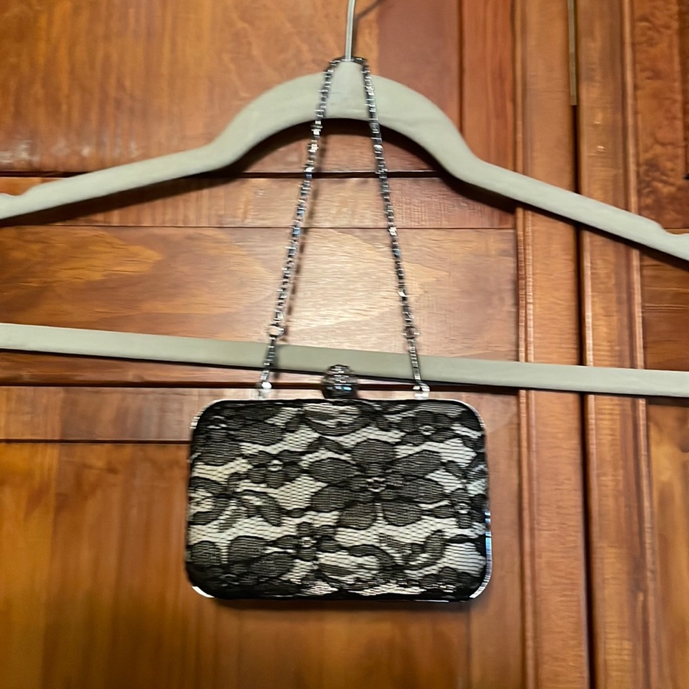 Lace hard case wristlet with chain detail and decorative gem closure